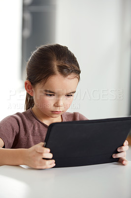 Buy stock photo Shot of an adorable little girl reading a digital tablet