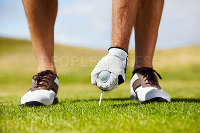 Buy stock photo A golfer putting his tee into the ground on the golf course