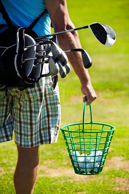 Buy stock photo Cropped image of a golfer carrying a bucket of balls
