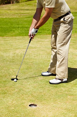 Buy stock photo Ball, hole and man on golf course to aim for target, winning and training in contest, competition and challenge. Closeup of athlete, golfing club and action on grass for summer sports, games and gear