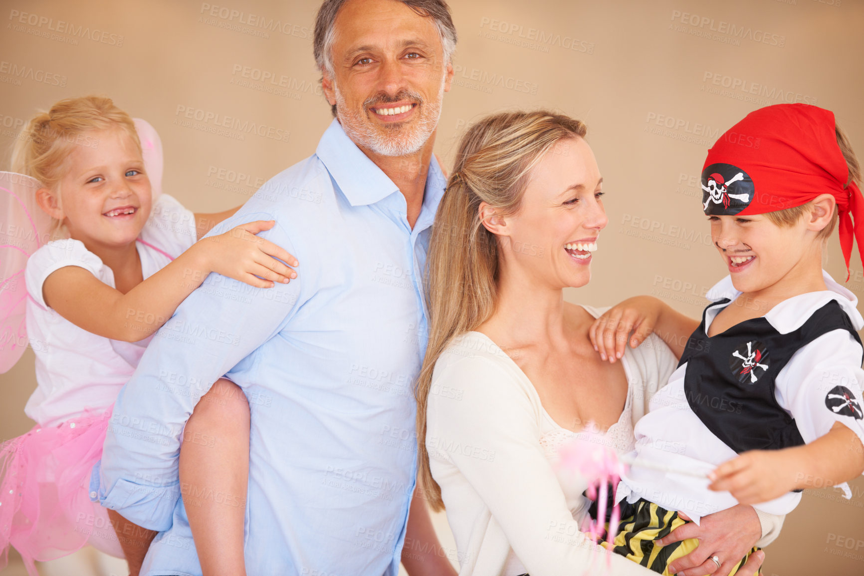 Buy stock photo A family portrait of a father piggybacking his daughter and bother carrying her son on halloween