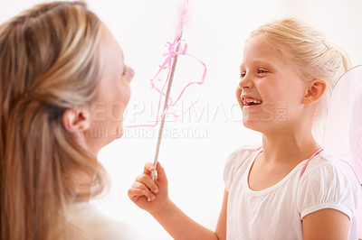 Buy stock photo A smiling girl dressed up as a fairy and holding a wand standing infront of her mother