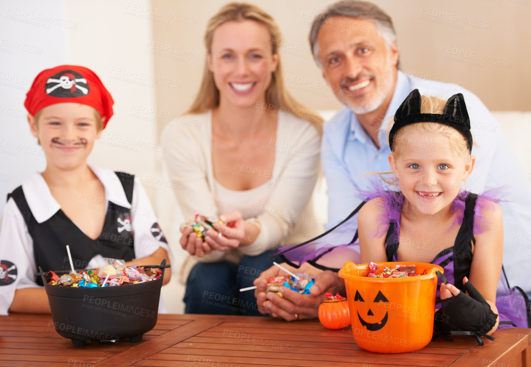 Buy stock photo Happy family, portrait and halloween party in home, trick or treat and happiness in childhood. Man, woman and kids for holiday with candy, pumpkin and fairy costumes for love and celebration in house