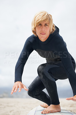 Buy stock photo Portrait, beach and a man surfing instructor on sand, teaching balance, skill or technique. Fitness, summer and a young person in a wetsuit on a surfboard as a sports coach on the coast in Australia