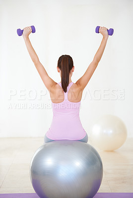 Buy stock photo Woman, back and workout on ball, dumbbells and balance in gym, training and strong muscle in arms. Girl, workout and exercise with pilates, weightlifting and hard work for health, wellness and body