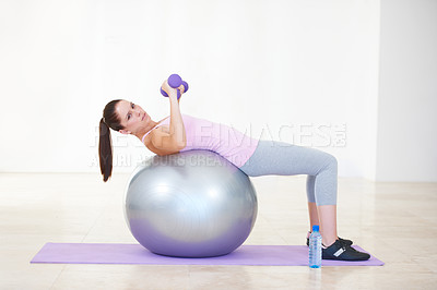 Buy stock photo Woman, lying and workout on ball, dumbbells and balance in gym, training and strong muscle in arms. Girl, portrait and fitness with pilates, weightlifting and hard work for health, wellness and body