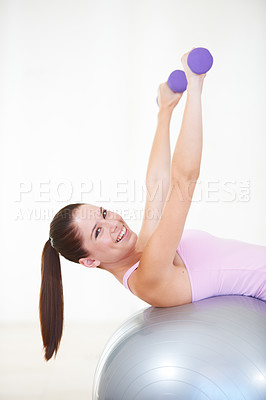 Buy stock photo Girl, lying and exercise on ball, dumbbells and balance in gym, training and strong muscle in arms. Woman, portrait and fitness with workout, weightlifting and hard work for health, wellness and body
