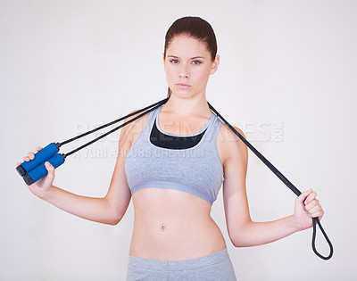 Buy stock photo Woman, portrait and skipping rope in studio for exercise cardio or progress training, workout on white background. Female person, face and gym for active lose weight or strong, practice or jumping
