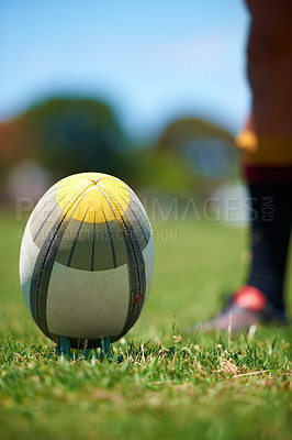 Buy stock photo Closeup, rugby and leg with a ball of a player to kick for fitness training on a grass field. Man, uniform and sports exercise for healthy green lawn and active athlete playing for health 