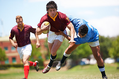 Buy stock photo Full length shot of a young rugby player trying to avoid a tackle