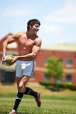 Buy stock photo Sports, rugby and fitness man with ball on field for training, wellness and morning cardio outdoor. Handball, exercise and topless male player happy at stadium for competition, action or performance