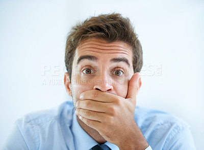 Buy stock photo Portrait of a young businessman covering his mouth with his hand