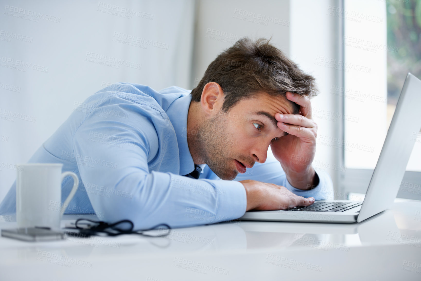 Buy stock photo A exhausted businessman falling asleep behind his laptop