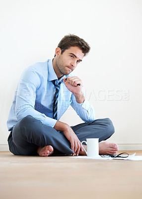 Buy stock photo Stress, documents and thinking with a business man reading tax paper or a budget on the floor of his apartment. Accounting, finance and anxiety with a young employee looking worried about debt