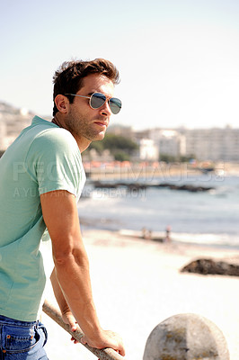 Buy stock photo Thinking, fashion and man by ocean in city for summer holiday, vacation and weekend outdoors. Sunglasses, travel and confident person by sea in trendy clothes, style and casual outfit to relax