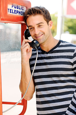 Buy stock photo Telephone, happy and man in city by booth for communication, phone call and contact. Fashion, payphone and person in urban town for talking, speaking and conversation in trendy clothes and style