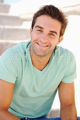 Buy stock photo Portrait of a handsome young man smiling while seated on a flight of stairs