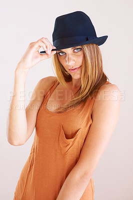 Buy stock photo Woman, fashion and portrait with hat in studio for confident, class and edgy attitude on wall background. Face, pose and female model with smart, casual or trendy outfit, unique style or fashionable