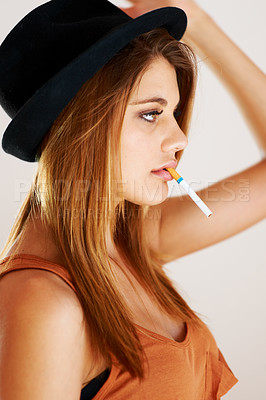 Buy stock photo Fashion, smoking and woman with cigarette in studio with style, attitude or edgy aesthetic. Smoke, profile and female model smoker with cool, confidence and trendy outfit with bad habit or addiction