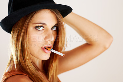 Buy stock photo A young trendy woman smoking a cigarette
