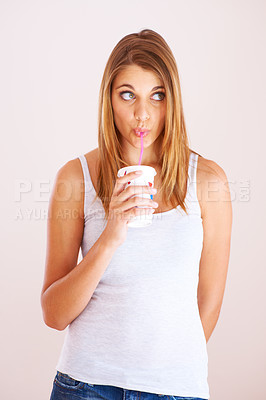 Buy stock photo Woman, drink and studio with cup of soda, fizzy cola and ice cold milkshake isolated on white background. Thirsty young girl, thinking and sip straw for takeaway beverage, juice or fast food smoothie
