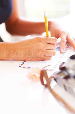 Buy stock photo Hands, pencil and writing on letter on table, thought and communication for envelope in apartment. Young person, paper message and mail with idea, thinking and courier to post vintage note in home