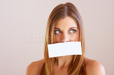 Buy stock photo Woman, looking and cover for mouth with mock up for silence in studio on white background. Female model, face and placard for talking, shh or quiet with copy space for announcement, secret or gossip