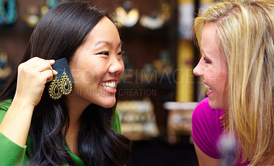 Buy stock photo A young Asian woman asking her friend for an opinion on a pair of earrings
