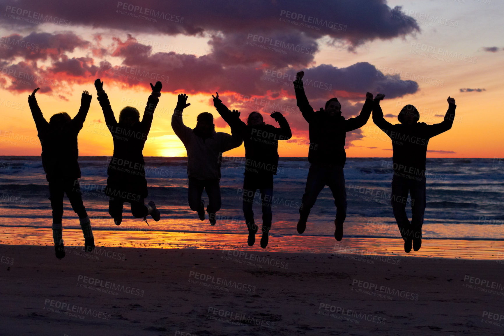 Buy stock photo Silhouette of a group of people jumping on the beach at sunset