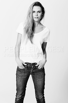 Buy stock photo Croppy studio portrait of a an attractive young woman standing with her hands in her pockets