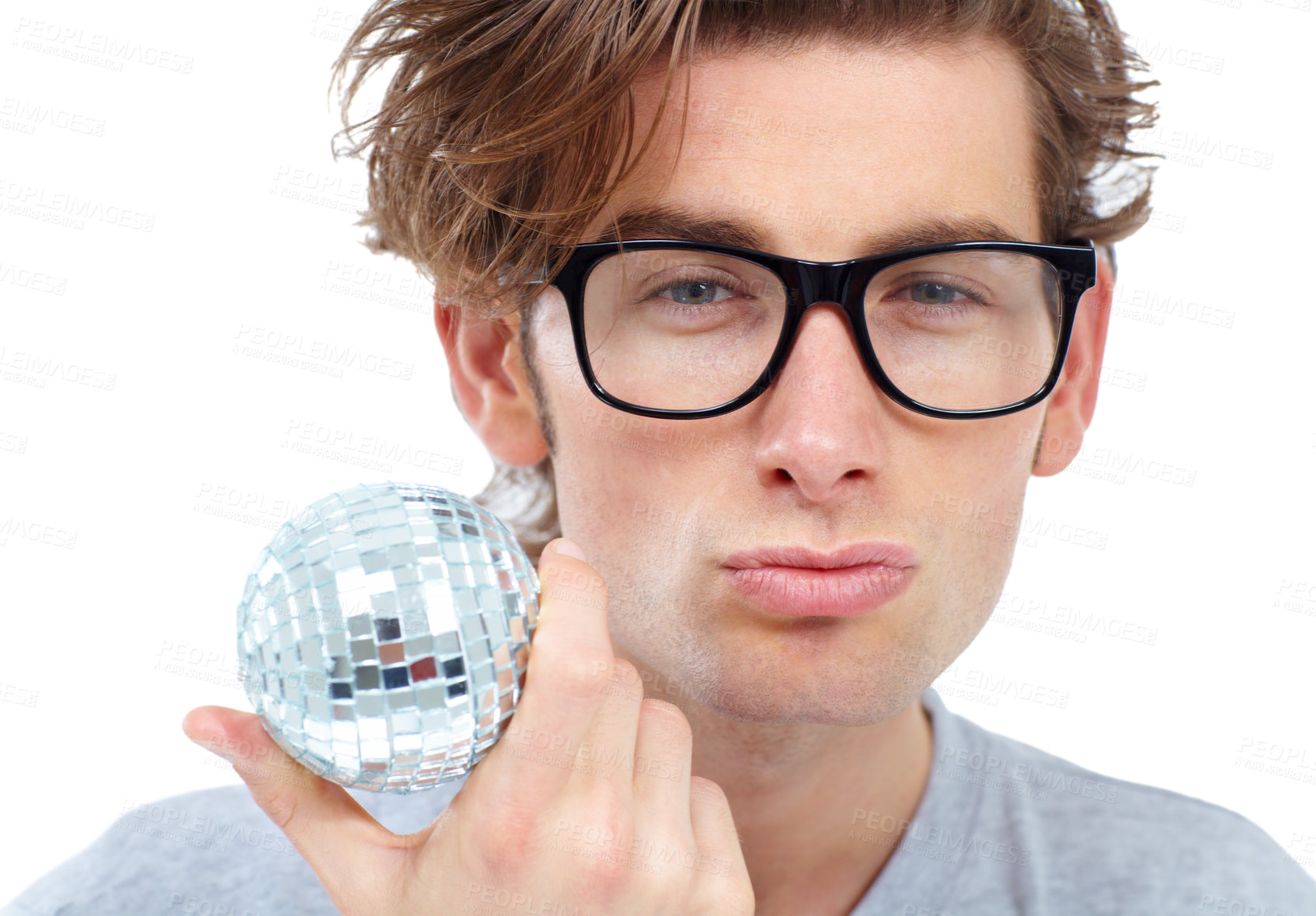 Buy stock photo Handsome young man pouting and holding a small disco ball