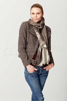 Buy stock photo Cropped studio portrait of a an attractive young woman standing with her hands in her pockets