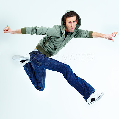 Buy stock photo Portrait of a young man posing while jumping in the air