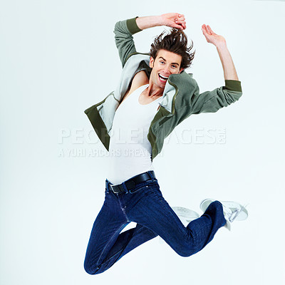 Buy stock photo Portrait of a happy young man jumping up into the air