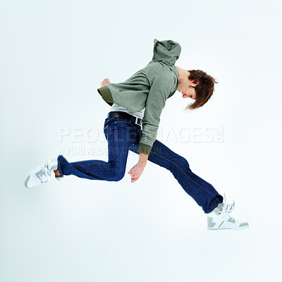 Buy stock photo Young man, leaping and fashion jumping in style, excitement or hip against a studio background. Happy male model in air jump with stylish casual clothing, jacket and jeans isolated on mockup