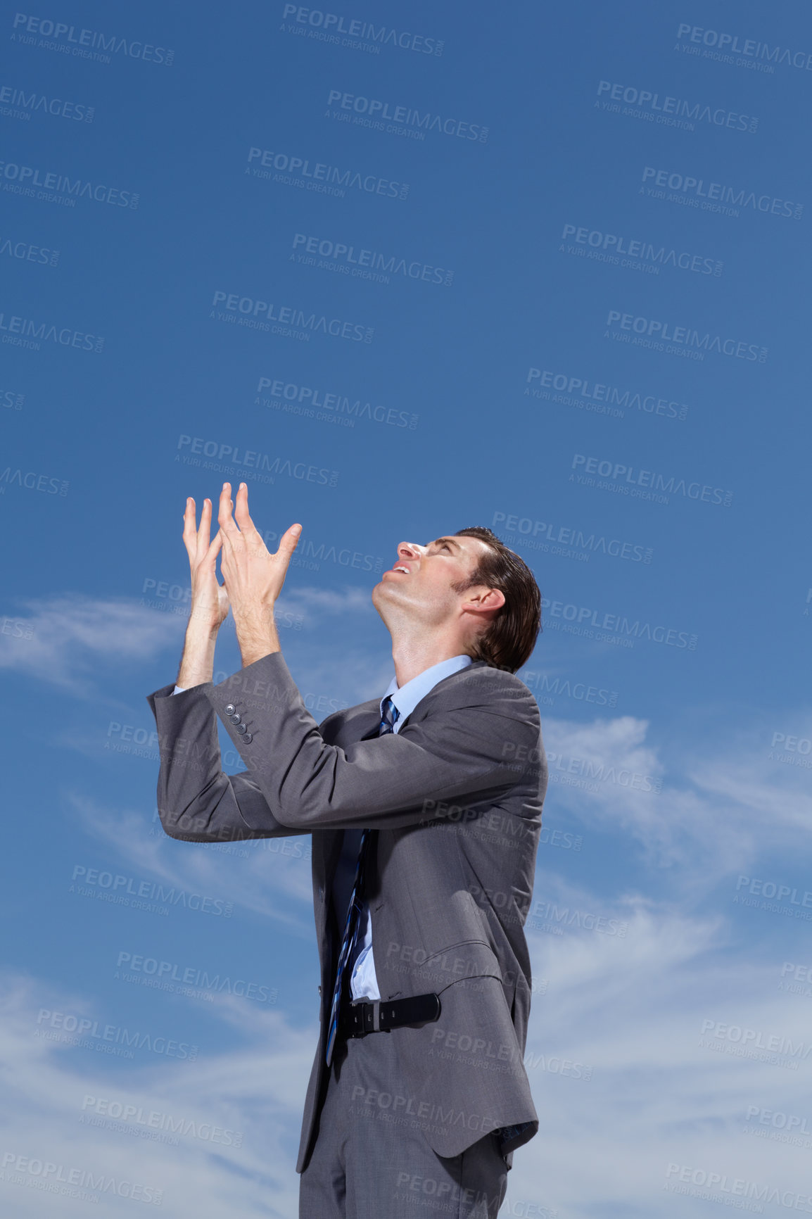 Buy stock photo A young businessman pleading to the sky for answers