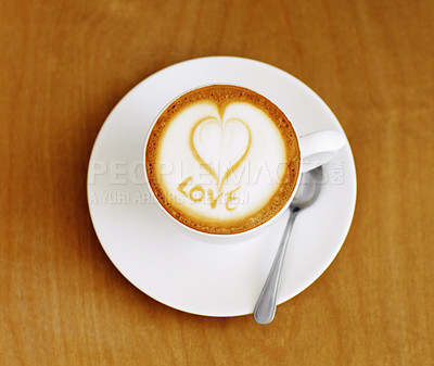 Buy stock photo Coffee cup, cappuccino and heart in foam on a table with no people in a restaurant and diner. Cafe drink, love writing and foamy beverage art with milk in a cafe with a closeup of mug and spoon