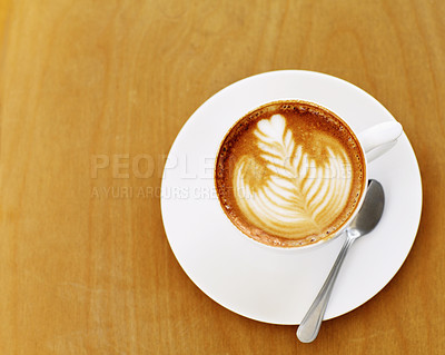 Buy stock photo High angle shot of an artistically prepared cup of cappuccino sitting on a cafe table