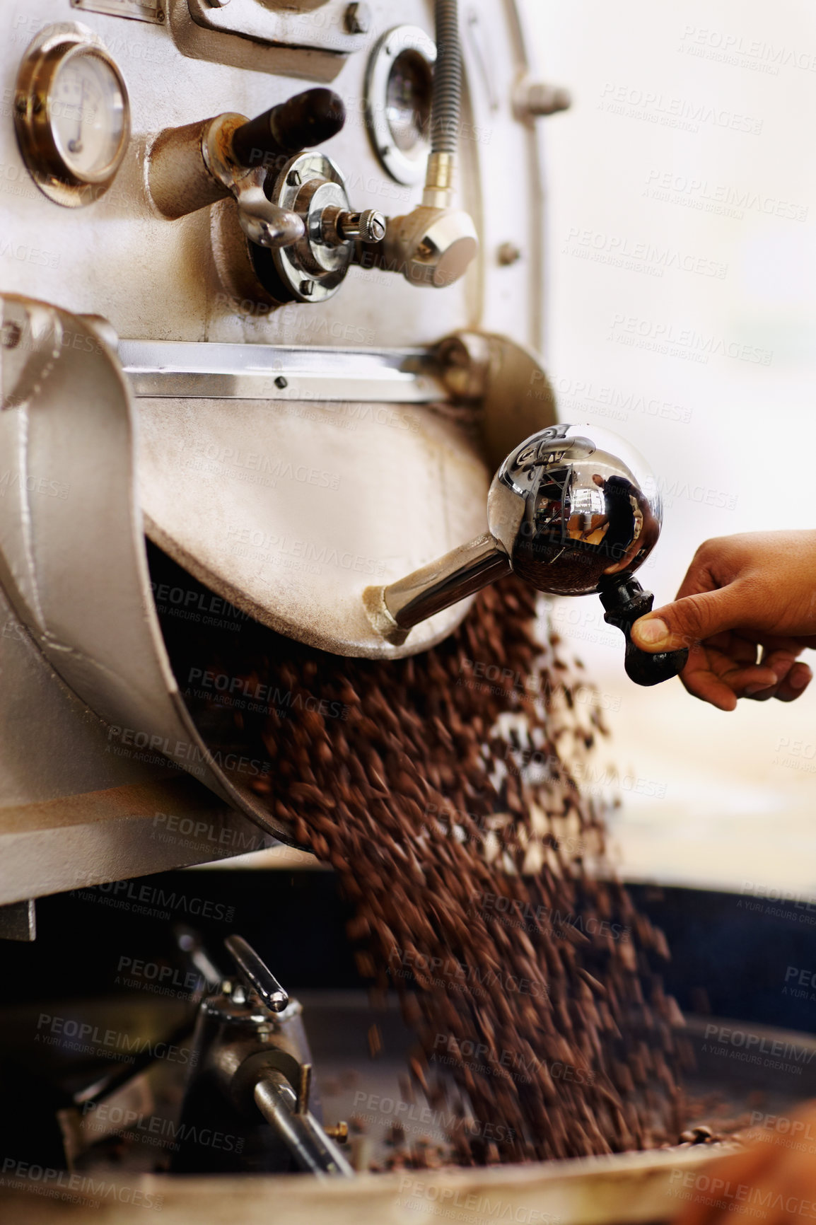 Buy stock photo Shot of coffee beans pouring into an industrial grinding machine