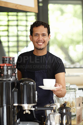 Buy stock photo Shot of a handsome barista serving up a fresh cup of coffee