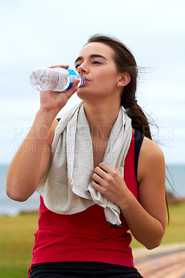 Buy stock photo A young woman drinking water after her workout