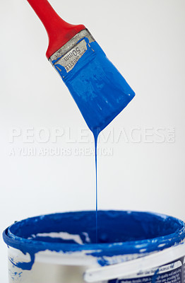 Buy stock photo Closeup of a paintbrush dripping blue paint into a bucket