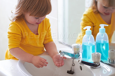 Buy stock photo An adorable little girl washing her hands in the bathroom 