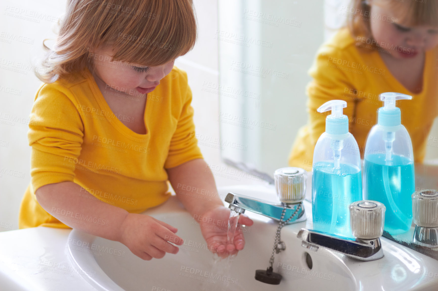 Buy stock photo An adorable little girl washing her hands in the bathroom 