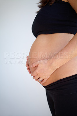Buy stock photo Expectant mother holding her pregnant belly - Cropped
