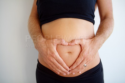 Buy stock photo Closeup, pregnant and woman with heart hands, stomach and health with childbirth, support or wellness. Zoom, pregnancy or female person touching belly, tummy or symbol for love with maternity or care
