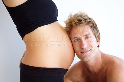 Buy stock photo Handsome young father to be listening to his pregnant wife&#039;s belly