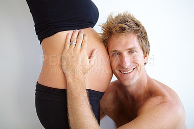 Buy stock photo Handsome young father to be listening to his pregnant wife&#039;s belly