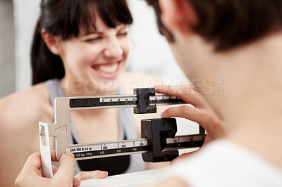 Buy stock photo Closeup cropped shot of a woman looking excited as her trainer measures her weight