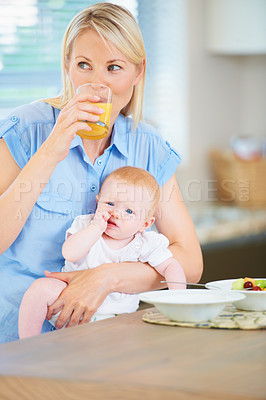 Buy stock photo A mother and her adorable baby girl sitting in the kitchen enjoying breakfast